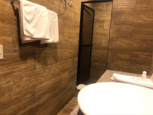 bagno con lavandino, servizi igienici e pareti in legno di Hotel Ambassador a Quito