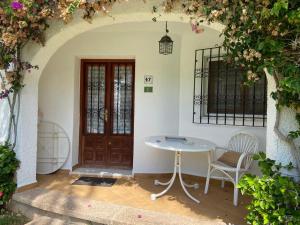 ein Zimmer mit einem Tisch und Stühlen vor einer Tür in der Unterkunft Apartamento Urb Oasis Park II Denia, las Marinas in Denia