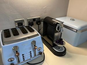 a kitchen counter with a coffee maker and a toaster at Honeybee Cottage, with a log fire & a hot tub. in Bradford