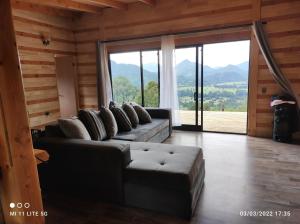 Rancocabaña vista nilahue的带沙发和大窗户的客厅