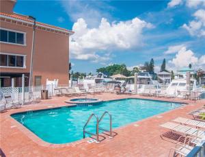 a pool at a resort with chairs and a building at Madeira Bay Resort II by Travel Resort Services in St Pete Beach
