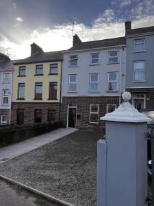 a large white building with a brick building at Westland Suites - Stylish, Modern, Elegant, Central Apartments A in Derry Londonderry