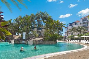 two people in a swimming pool at a resort at Calypso Plaza Resort Unit 306 in Gold Coast +7 photos