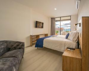 a hotel room with a bed and a couch at HOTEL SAN PEDRO PITALITO in Pitalito