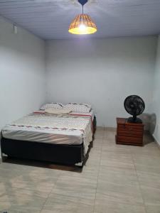 1 dormitorio con cama, lámpara y cómoda en Suítes Pirenópolis, en Pirenópolis