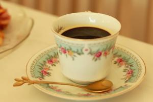 a cup of coffee on a plate with a spoon at Hotel & Suites Mo Sak in Tapachula