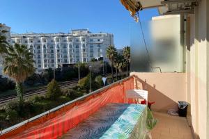 uma varanda com um banco e vista para um edifício em 2 rooms facing south 300m from the Croisette LIVE IN LE BOSQUET em Cannes