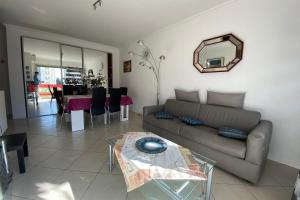 uma sala de estar com um sofá e uma mesa em 2 rooms facing south 300m from the Croisette LIVE IN LE BOSQUET em Cannes