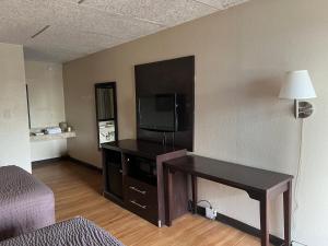a living room with a flat screen tv and a table at Knights Inn Ashland in Ashland