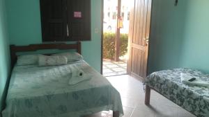 a bedroom with a bed and a door to a patio at Pousada Pampulha in Salinópolis