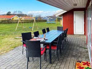 ノーポにある12 person holiday home in Nordborgのパティオ(テーブル、椅子、プレイグラウンド付)
