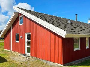 ノーポにある12 person holiday home in Nordborgの黒屋根の赤い建物