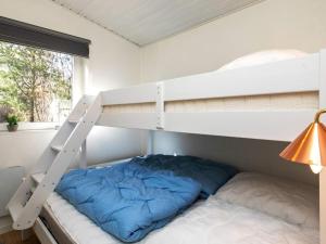 1 dormitorio con litera y almohada azul en Holiday home Hurup Thy XVIII, en Sønder Ydby