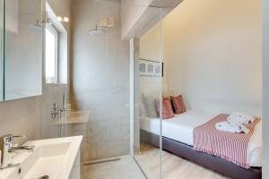 a small bathroom with a bed and a shower at Tiara Downtown Apartments by DA'HOME in Porto