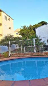 a fence around a swimming pool next to a building at Casarão Hostel Cuiabá in Cuiabá