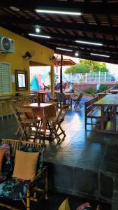 a patio with wooden tables and chairs and a table and tablesktop at Casarão Hostel Cuiabá in Cuiabá