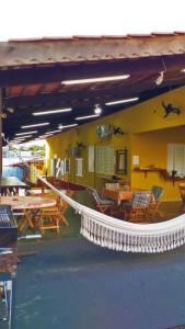 a restaurant with tables and chairs and a white railing at Casarão Hostel Cuiabá in Cuiabá