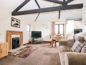 a living room with a fireplace and a tv at The Granary in Henfield