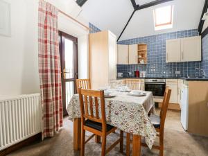 uma sala de jantar com uma mesa e cadeiras numa cozinha em The Granary em Henfield