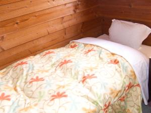 1 dormitorio con cama con edredón y almohada en Yamanakako Pension Pause en Yamanakako