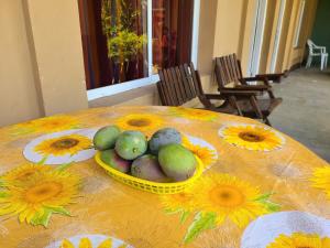 a yellow bowl of fruit on a table with sunflowers at Sophie House in Moyogalpa