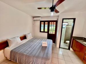 ein Schlafzimmer mit einem Bett und einem Deckenventilator in der Unterkunft Duplex Aconchegante Residencial Mont Sinai in Porto Seguro + 24 Fotos
