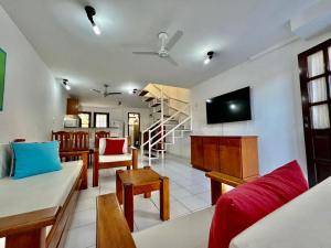 ein Wohnzimmer mit Sofa und Fernseher in der Unterkunft Duplex Aconchegante Residencial Mont Sinai in Porto Seguro