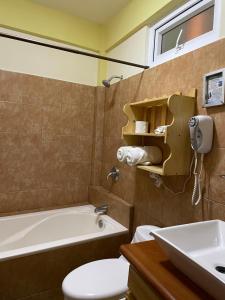 a bathroom with a tub and a toilet and a sink at Hotel-Villas JABEL TINAMIT in Panajachel