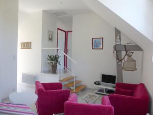 - un salon avec des chaises violettes et un escalier dans l'établissement Apartment, Erquy, à Erquy