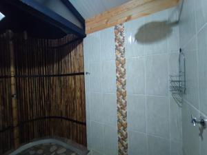 a bathroom with a shower with a wooden ceiling at Cabaña Glamping Los Canarios San Rafael, Antioquia in San Rafael