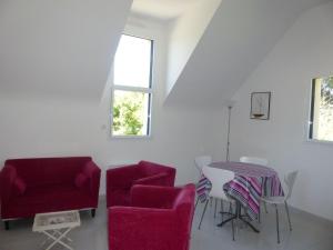 - un salon avec des chaises rouges et une table dans l'établissement Apartment, Erquy, à Erquy