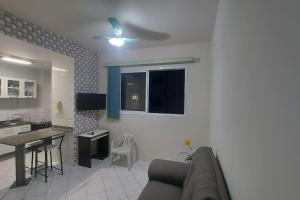 Lindo apartamento com Wi-Fi a 370m da Praia do Morro, próximo ao Marlim Azul e à Av Paris في غواراباري: غرفة معيشة مع أريكة ومطبخ +37 صورة