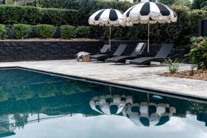 a swimming pool with lounge chairs and an umbrella at Maleny Lodge in Maleny