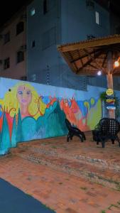 a wall with a mural of a woman on it at Casarão Hostel Cuiabá in Cuiabá