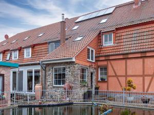 a house with a pond in front of it at Budget Apartment in Grundshagen with garden seating in Klütz