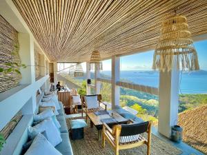 a living room with couches and a view of the ocean at Organica Yoga Shelter in Paquera