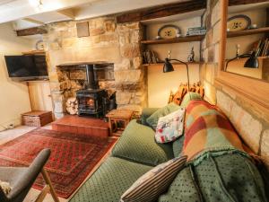 a living room with a couch and a fireplace at Bulmers Cottage in Staithes