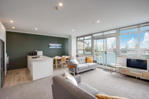 a living room with a couch and a tv at Coastal Crib - Napier Holiday Apartment in Napier