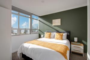 En eller flere senge i et værelse på Coastal Crib - Napier Holiday Apartment