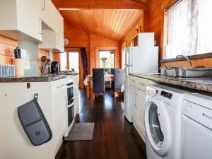 a kitchen with a washer and dryer in a cabin at Hazel Lodge in Bodmin