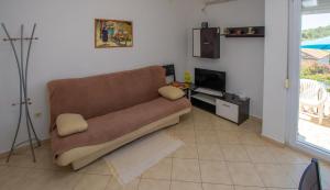 a living room with a couch and a television at Apartments Calida A in Drage