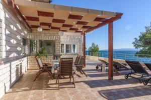 un patio con sillas y una mesa y vistas al océano en Apartment Helli, en Trogir