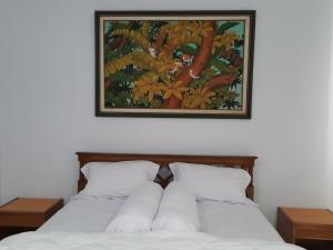 ein Schlafzimmer mit zwei Betten mit einem Bild darüber in der Unterkunft C4 homestay in Jakarta