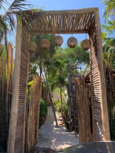 an entrance to a garden with a wooden fence at Chiibal in Tulum