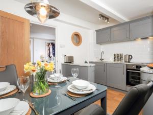 een keuken met een tafel en stoelen en een eetkamer bij 35 The Salcombe in Salcombe