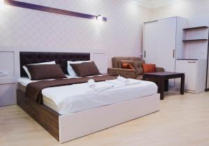 a bedroom with a large bed and a living room at EMEG Hotel in Batumi