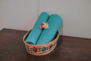 Una cesta llena de toallas verdes con una flor. en Abrakadabra 747 en Timuran