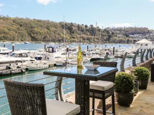 una mesa con sillas y una botella de vino en la parte superior de un puerto deportivo en Quayside, Dart Marina, en Dartmouth
