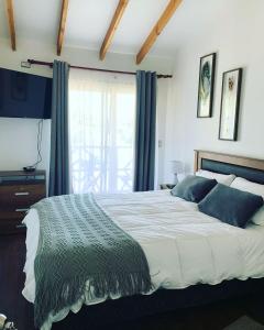 um quarto com uma cama grande e uma janela em Hostal Uruz em Coihaique