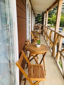 - une terrasse couverte avec 2 bancs, une table et des chaises dans l'établissement Hostal Uruz, à Coyhaique
